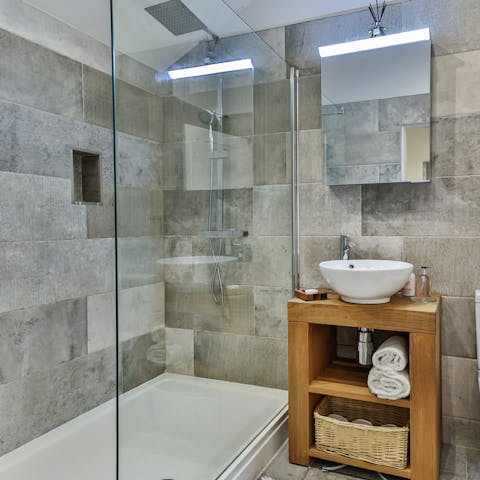 Feel anew beneath the rainfall shower of the immaculate bathroom