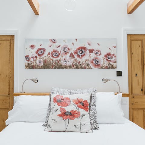 Drift off to sleep underneath the wooden beams and vaulted ceilings in the main bedroom