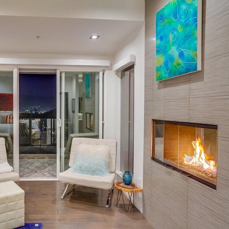 Get cosy by the fireplace, with the twinkling city skyline just behind you