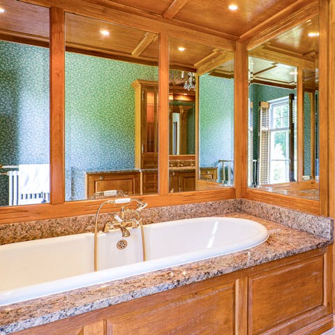 Treat yourself to a leisurely soak in the mirrored bathtub