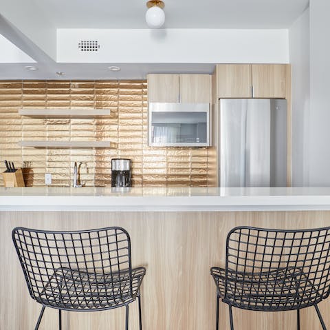 Sip your coffee in the contemporary gold-tiled kitchen