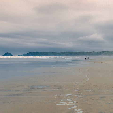 Sink your toes in the sand at Perranporth Beach, twenty minutes away by car