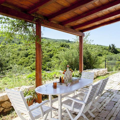 Gather beneath the wooden pergola for a game of cards around the table, sipping good wine