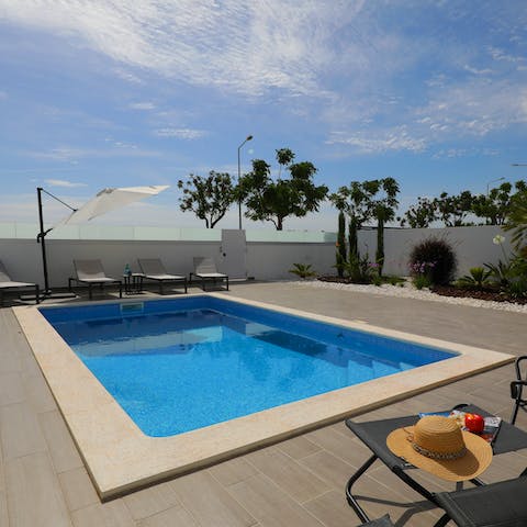 Enjoy a morning swim in the villa's pool before dozing off on a sun lounger