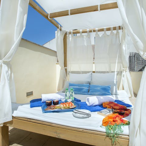 Enjoy a lazy lunch and a glass of wine on the sun-soaked day bed