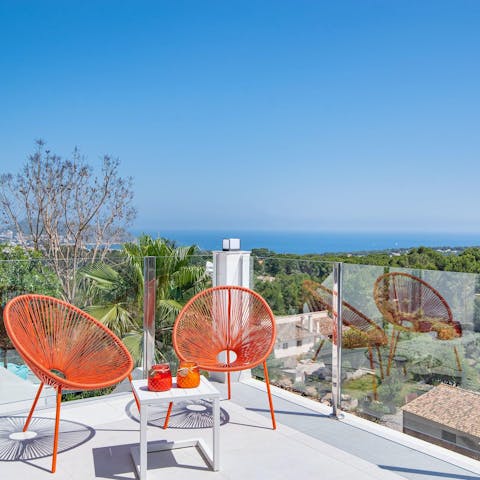 Enjoy views of the sea in the distance from the balcony's seating area