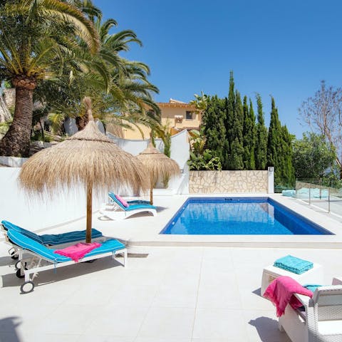 Relax under a Tiki parasol by the private outdoor pool