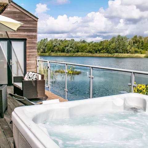 Unwind in the private hot tub with a spectacular lake backdrop