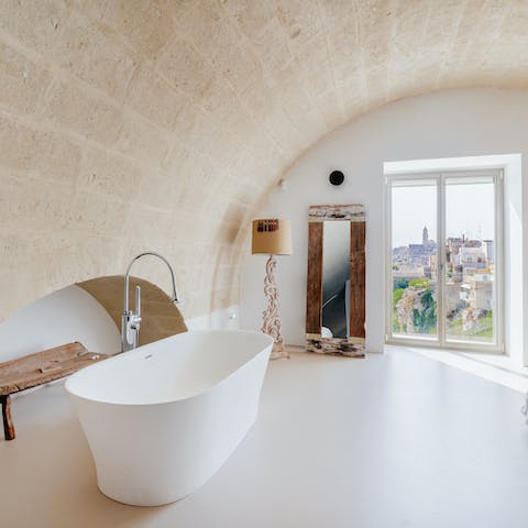 Treat yourself to a long soak in the bedroom's tub while delighting in Matera vistas