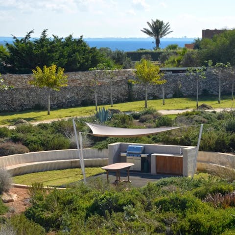 Find the barbecue area tucked amid a Mediterranean-style garden