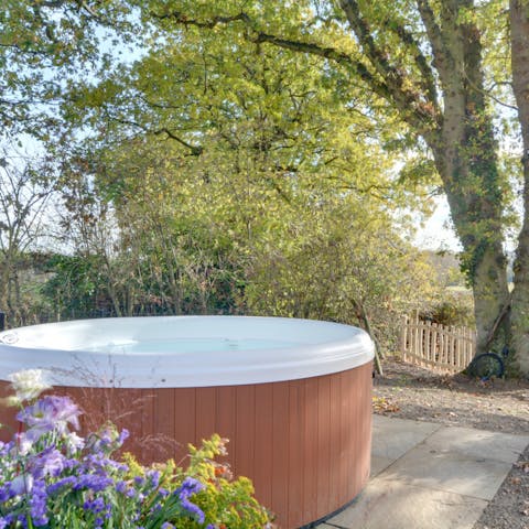 Unwind in the bubbling hot tub with views over the countryside 