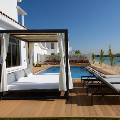 Jump into the villa's swimming pool and dry off on the day bed afterwards