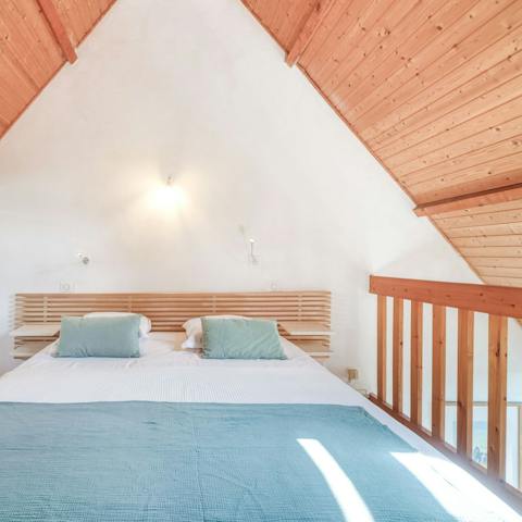 Admire the striking architecture of wooden, vaulted ceilings in the mezzanine bedroom