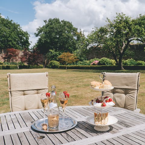 Sit out under the sun with a glass of bubbly and afternoon tea
