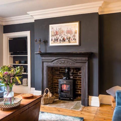 Snuggle up by the wood-burning fireplace in the royal blue living room