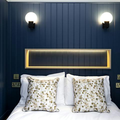 Get some rest in the bedroom with its navy blue wood panelling 