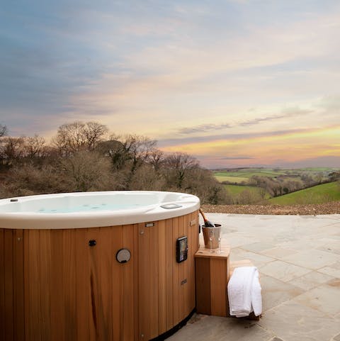 Admire the sweeping views of the Devon countryside from the hot tub