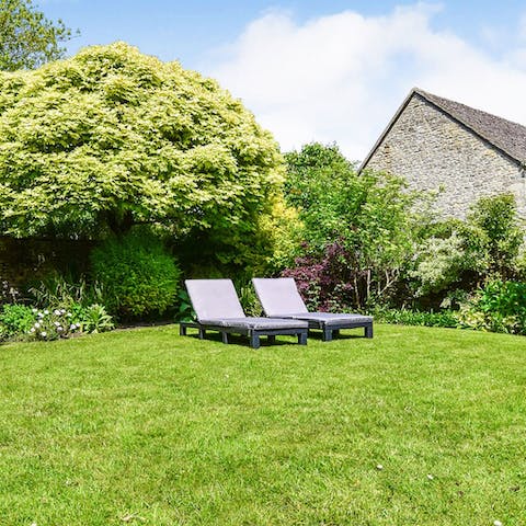 Make the most of the rare English sun and relax on the sun loungers, reading a book in your manicured garden