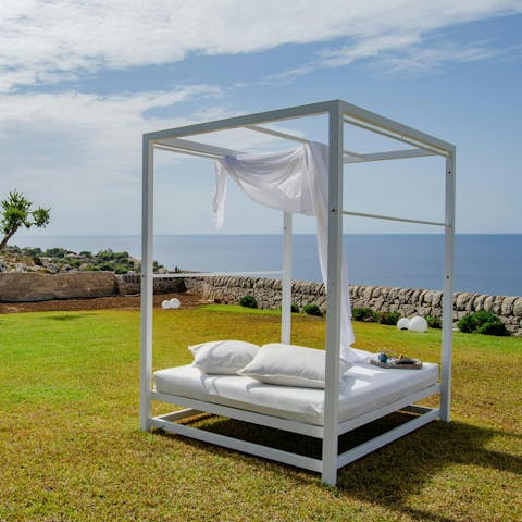 Relax on the day bed, with far-reaching sea views