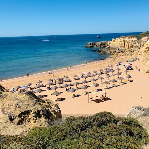 Sink your feet into the sea at Praia de Carvoeiro beach, just 1km away