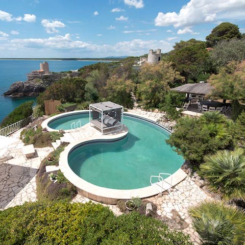 Enjoy the uniquely shaped pool shaded by greenery