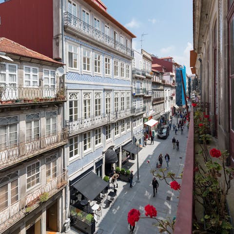 Peer down onto Baixa's bustling streets with your morning coffee