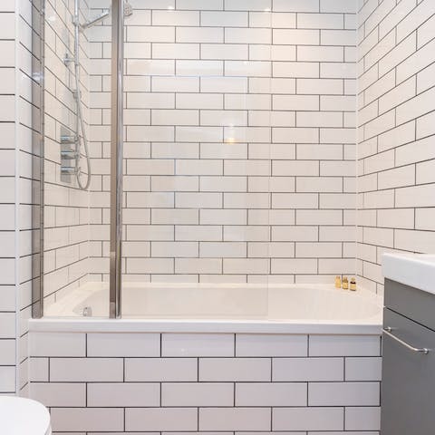 Treat yourself to a soak in the metro-tiled tubs
