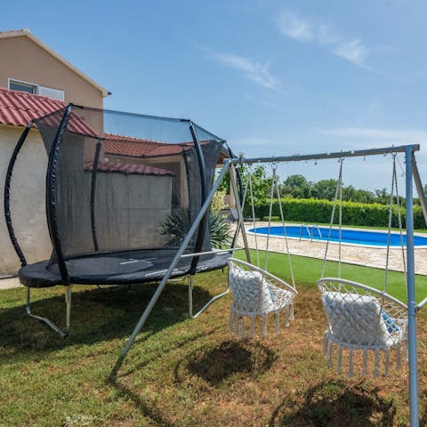 Jump on the trampoline with the kids in the garden