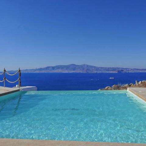 Spend hot afternoons swimming in the pool while looking out to Santorini island
