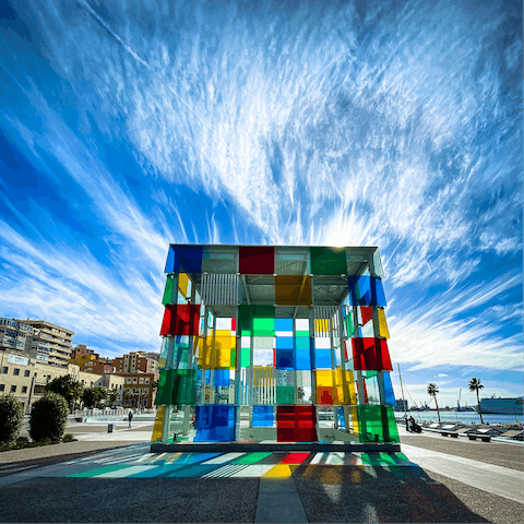 Admire the glass cube of Centre Pompidou Malaga, a twenty-minute walk away