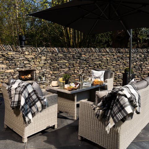 Relax in front of the fire in the courtyard with its woodland views