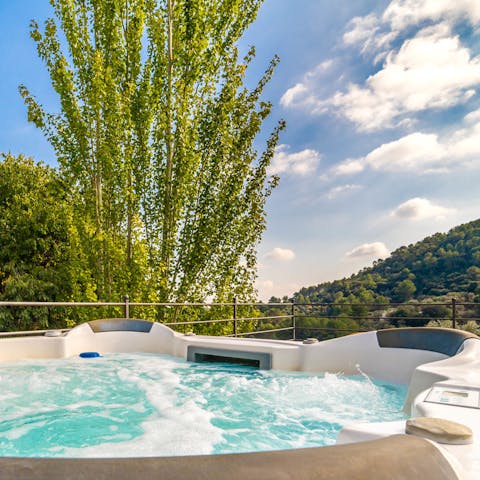 Enjoy a soak in the hot tub, a glass of bubbly in hand