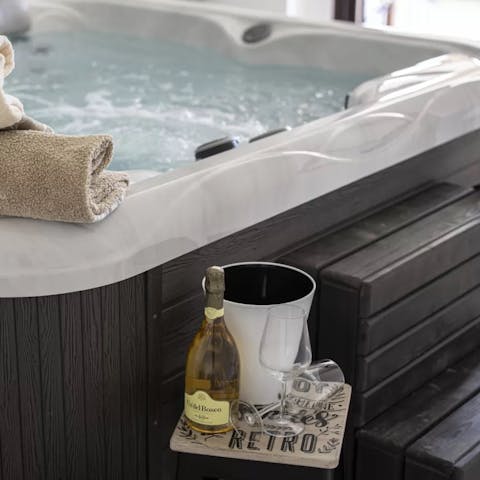 Unwind in the jacuzzi hot tub with a glass of local Italian wine in hand
