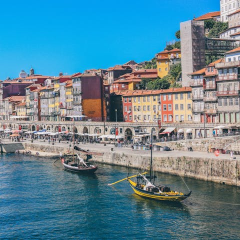 Explore bustling Cais da Ribeira along the Douro River, an eighteen-minute walk away