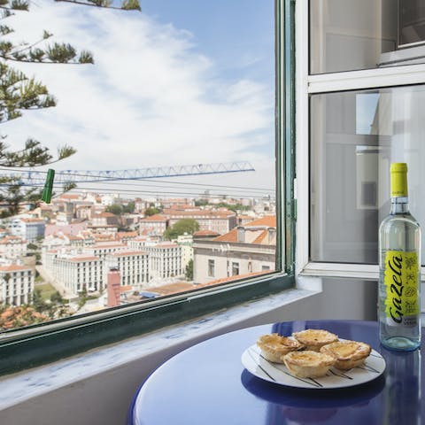 Enjoy a glass of locally-produced wine and pastéis de nata overlooking the city