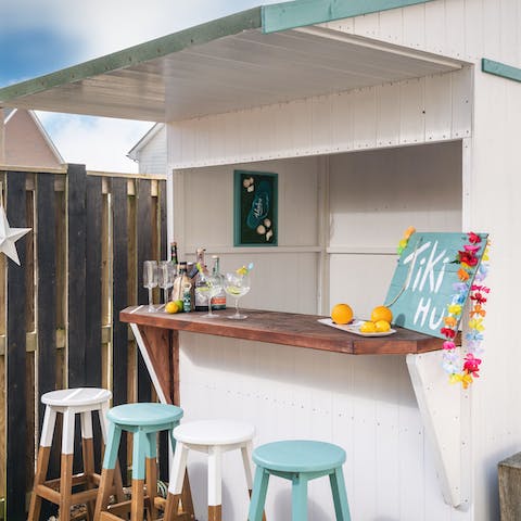 Mix a cocktail at the charming outdoor tiki bar