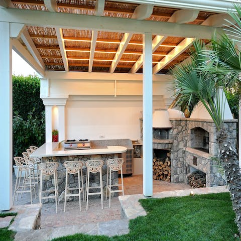 Host a dinner party in the garden equipped with a barbecue and outdoor kitchen