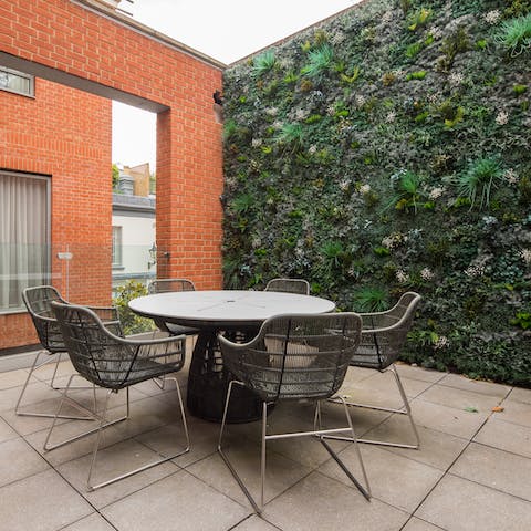 Drink and dine outside on the balcony against a backdrop of greenery