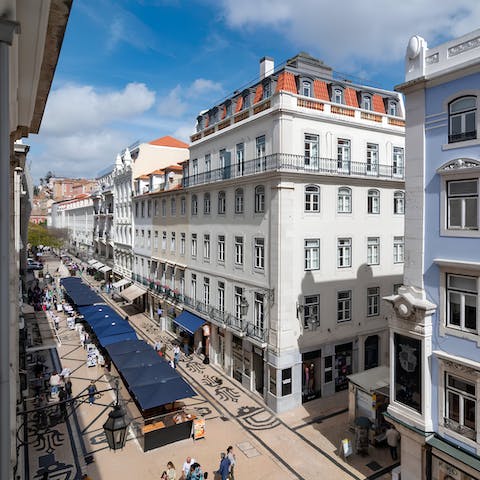 Soak up the views of Baixa’s bustling street scene below