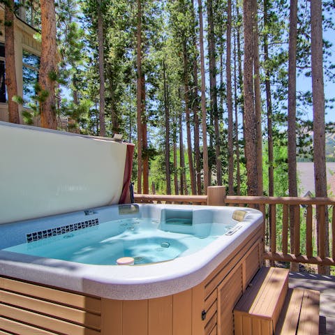 Warm up in the hot tub under the pines 