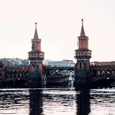 Stroll along the Spree River towards the Oberbaumbrücke Bridge