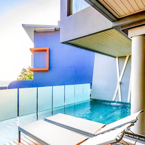 Relax poolside with sparkling views over the Andaman Sea from your private balcony