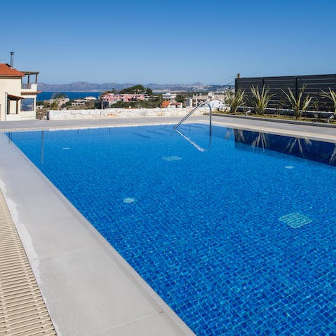 Swim in the private pool as the sea sparkles in the distance