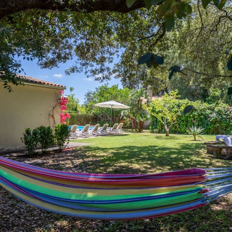 Relax in the hammock under the shade of the garden's oak tree