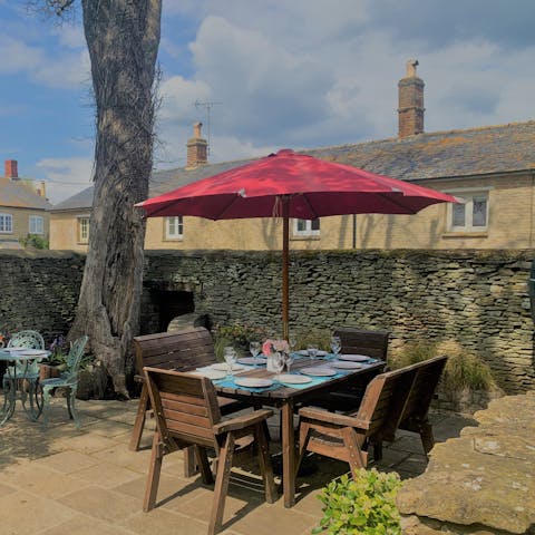 Enjoy alfresco dining under the shade of the parasol out on the patio