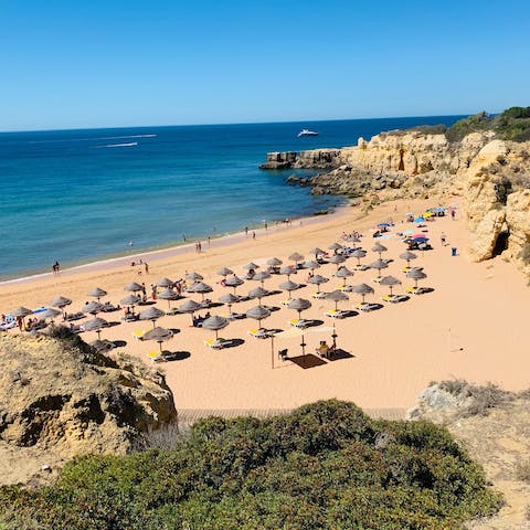 Sink your toes in the sand at Praia de Armação de Pêra, an eight-minute drive away