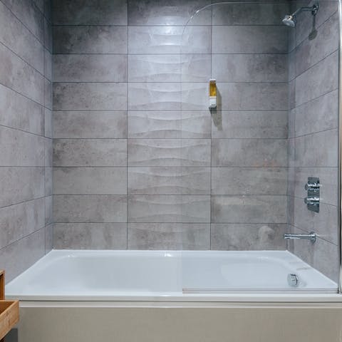 Treat yourself to a long soak in the sleek grey bathroom