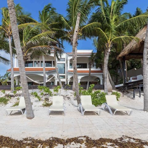 Sunbathe from your semi-private beach plot overlooking turquoise waters