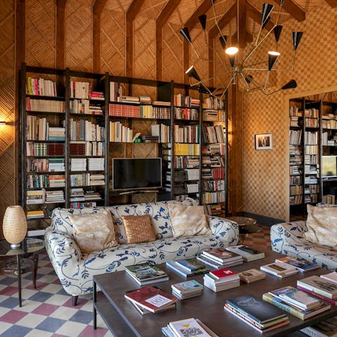 Select a book to delve into from the home's extensive library 