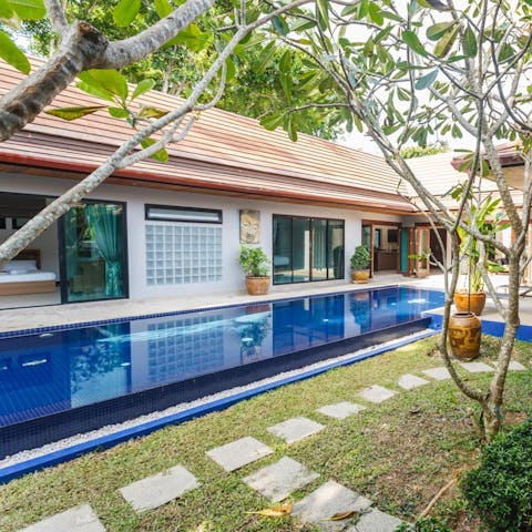 Swim in the fresh pool water guarded by the green leaves of hanging trees